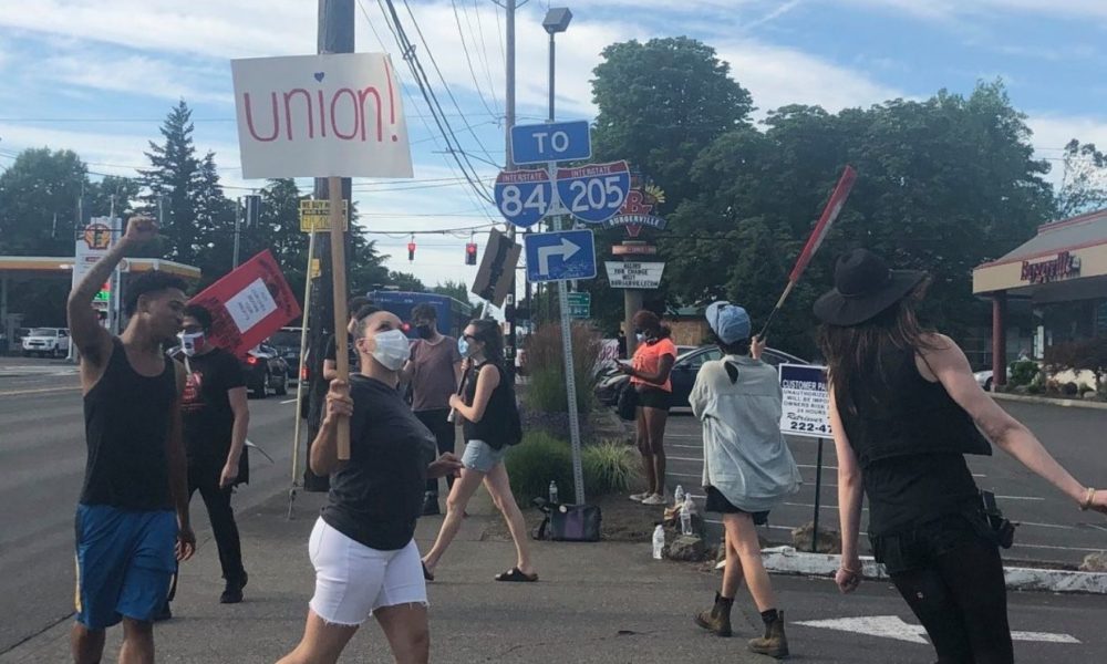 photo of people marching and carrying signs calling for a union outside a Burgerville restaurant