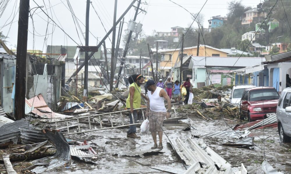 Two people survey the devastation created by Hurricane Maria in Puerto Rico in 2017, the morning after it hit