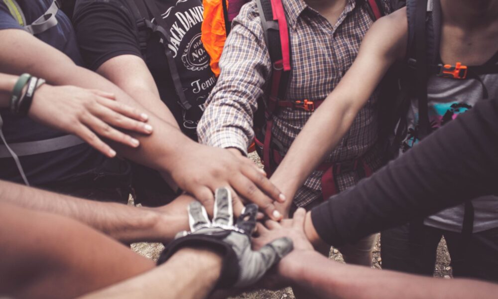 a group of people join hands in a circle