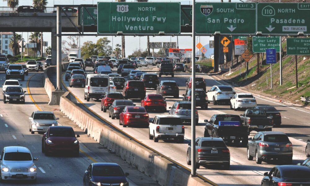 a highway filled with lots of traffic under a bridge