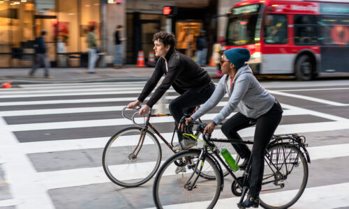 Two friends cycling together in downtown Los Angeles.