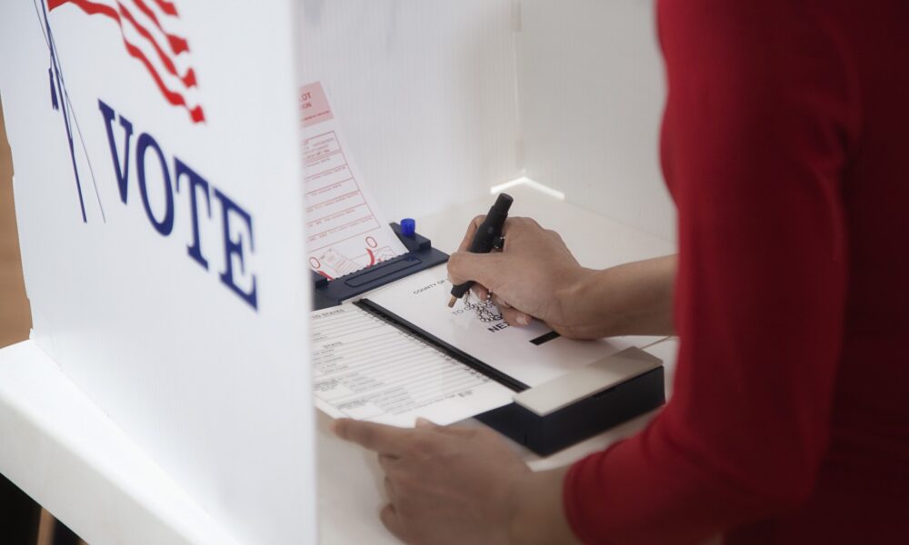 Voter contemplating ballot in polling booth