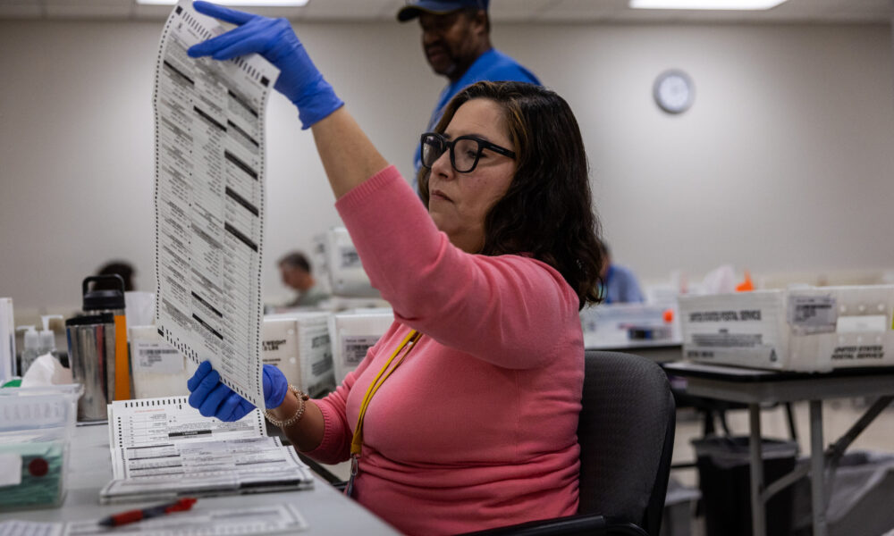 A woman looks at a ballot.