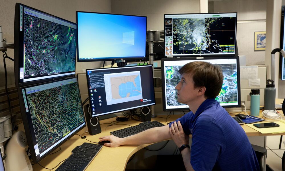 A hurricane specialist at the National Hurricane Center--an office under NOAA--tracks a developing storm on six separate computer monitors.
