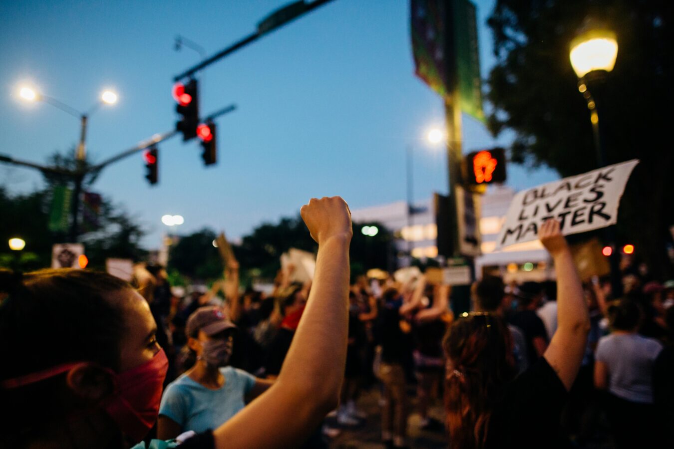 people at a protest one holding up a black lives matter sign