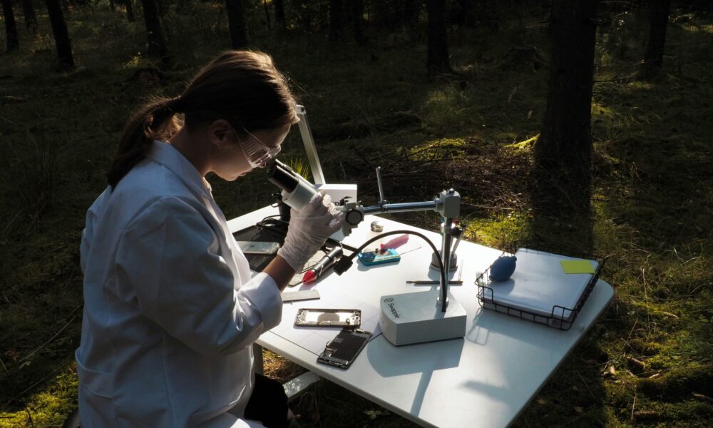 a woman in a lab coat conducts a scientific test outdoors.