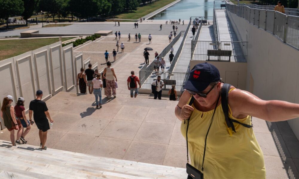 A tourist catches her breath after climbing the steps at the Lincoln Memorial during a heatwave.