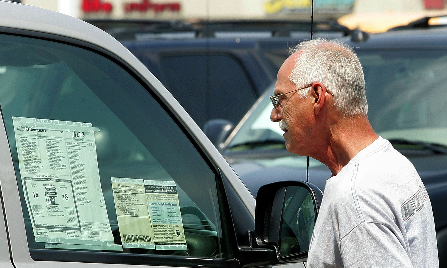 John Quentere Jr. looks at the window sticker of a new 2005 Chevy Blazer at Bredemann Chevrolet in Park Ridge, Illinois.