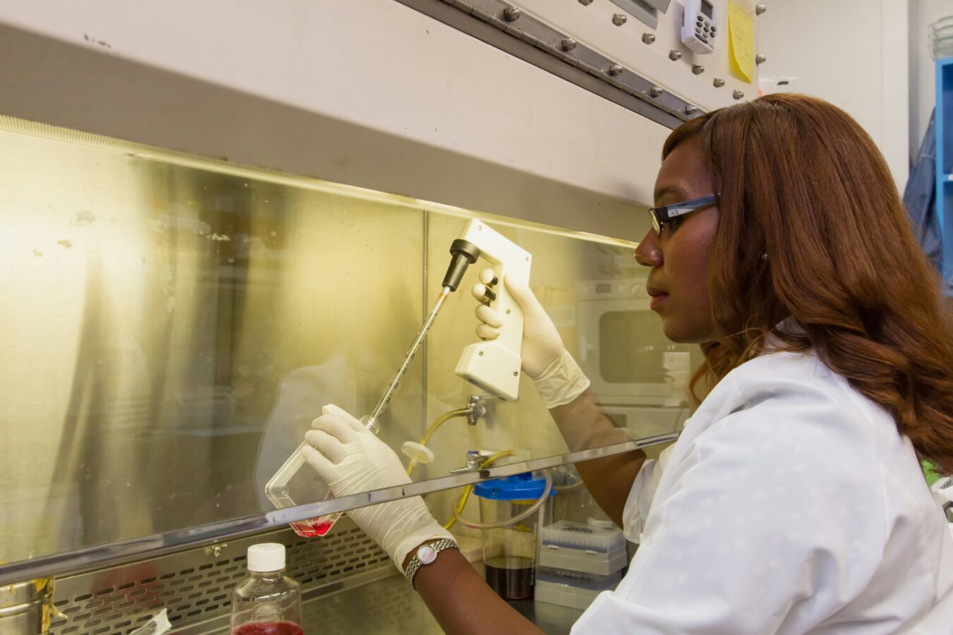 a woman in a lab coat testing a chemical