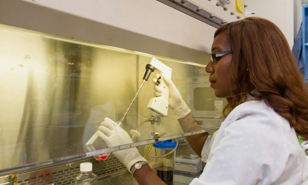 a woman in a lab coat testing a chemical