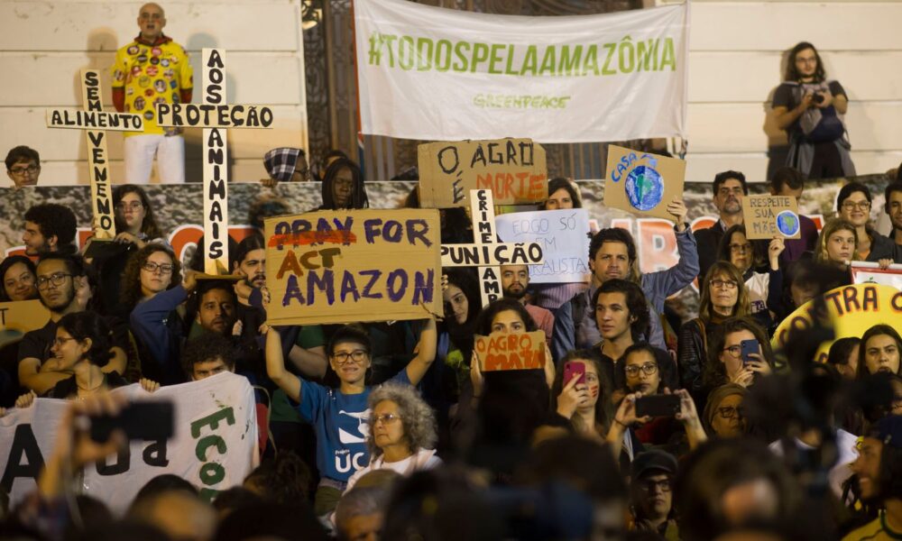 Brazilians gather in defense of the Amazon and protest against deforestation and forest fires in Rio de Janeiro, Brazil. One person holds a sign reading "act for Amazon"