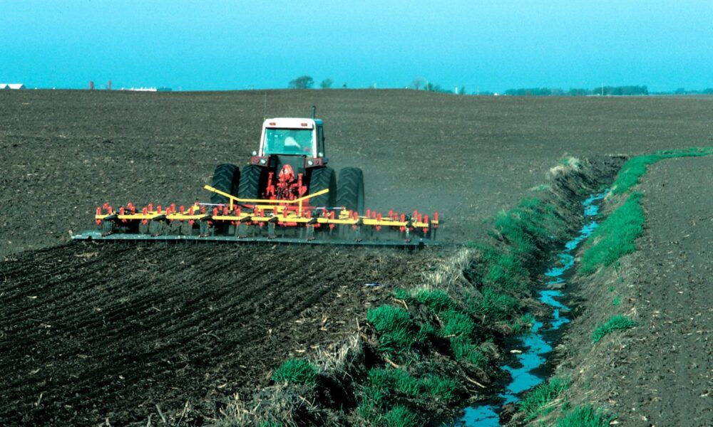 Image of a stream on farm land in Iowa without conservation riparian buffers