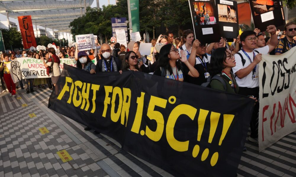 Activists, including some holding a banner that reads: "Fight for 1.5 degrees Celsius!!!", march at a prior UN COP conference