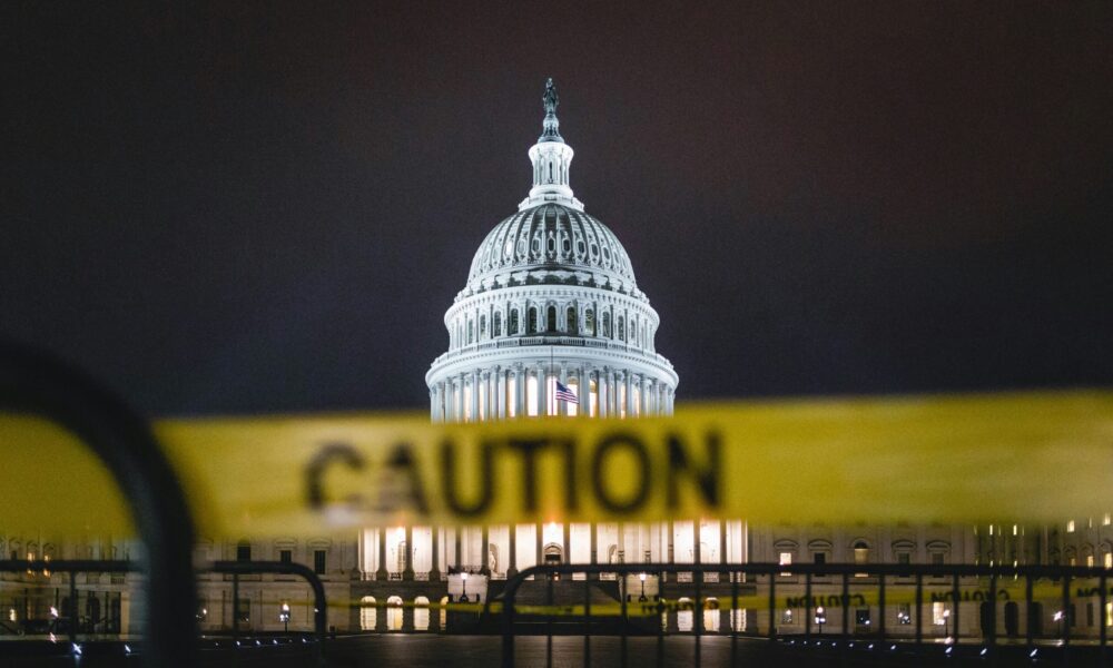 the US Capitol, seen from behind yellow caution tape