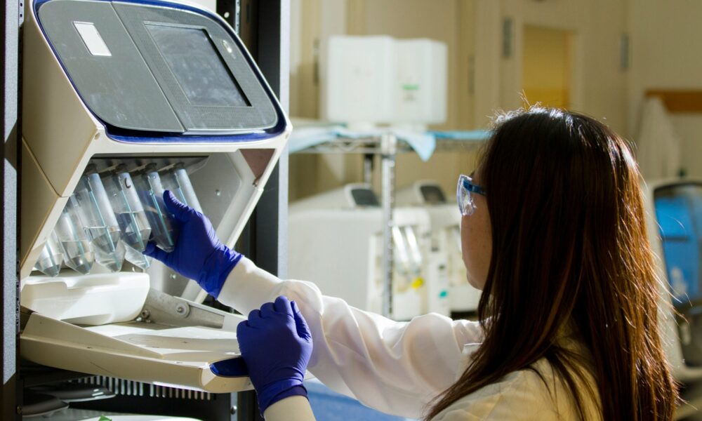 a woman in a research lab looking at test tubes
