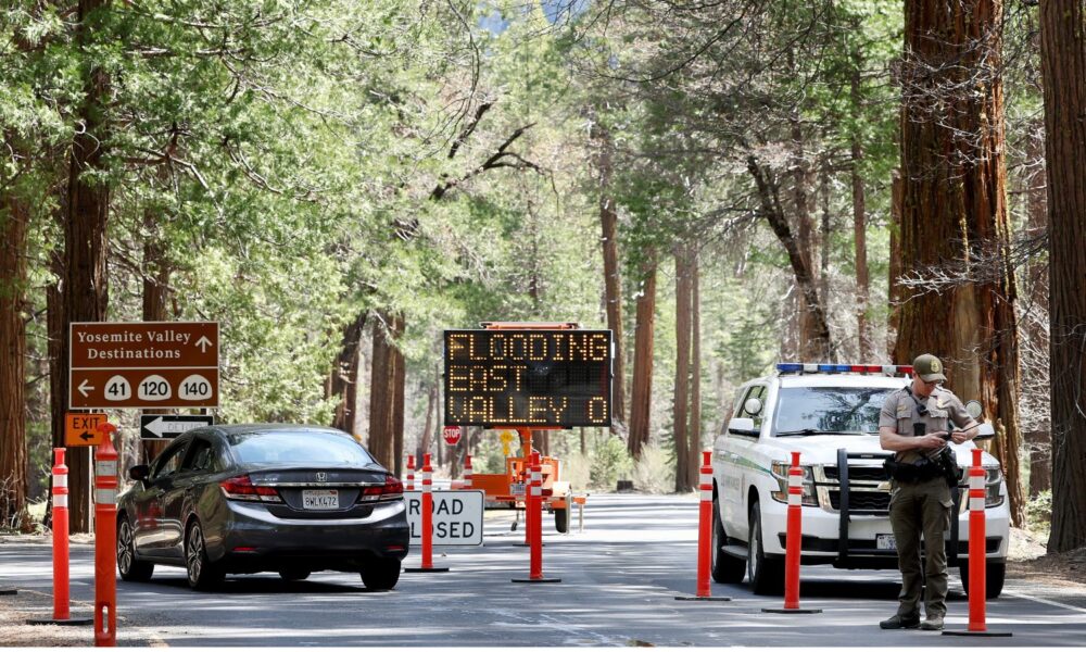 A park ranger checks in with a visitor at a checkpoint for a road closed due to flooding in Yosemite Valley, in a photo from 2023.