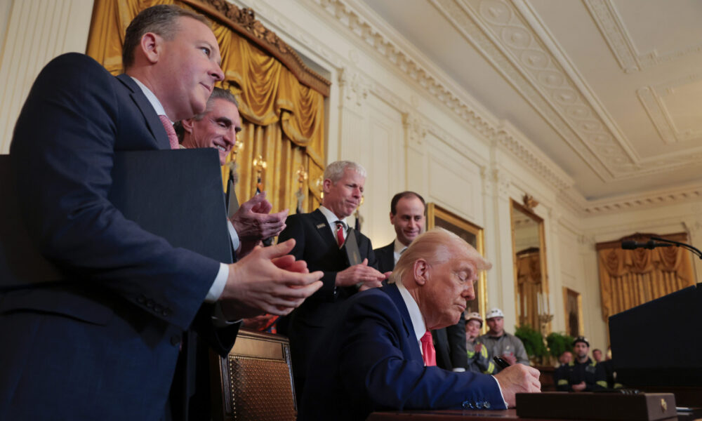 President Trump signs an executive order while appointees including Lee Zeldin, Doug Burgum and Chris Wright look on