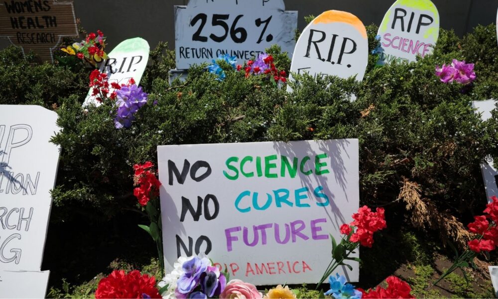 At a rally for funding science at NIH headquarters, a sign reads NO SCIENCE, NO CURE, NO FUTURE
