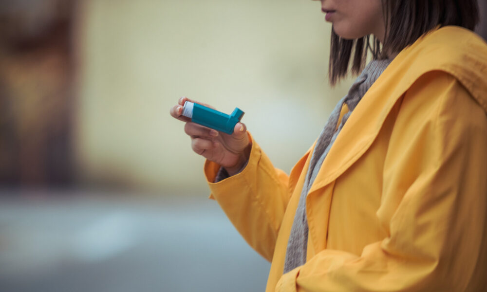 a young woman holding an inhaler